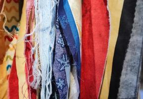 Detailed close up view on samples of cloth and fabrics in different colors found at a fabrics market photo
