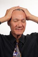 Mature man wearing a black shirt and tie with his hands on his head photo