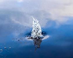 hermosa agua en un lago con agua salpicada y ondas en la superficie con nubes y reflejos de cielo azul foto