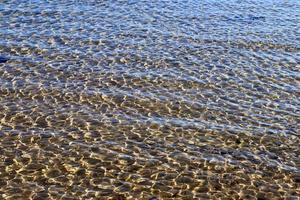 Detailed close up view on water surfaces with ripples and waves and the sunlight reflecting at the surface photo