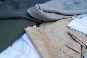 Detailed close up view on samples of cloth and fabrics in different colors found at a fabrics market photo