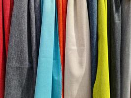 Detailed close up view on samples of cloth and fabrics in different colors found at a fabrics market photo