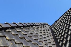 Roof window in velux style with black roof tiles. photo