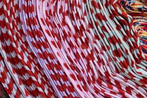 Detailed close up view on samples of cloth and fabrics in different colors found at a fabrics market photo