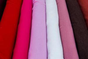 Detailed close up view on samples of cloth and fabrics in different colors found at a fabrics market photo