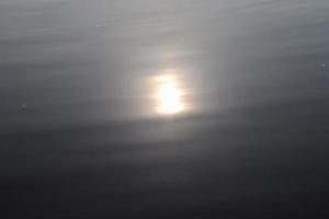 vista detallada de las superficies de agua con ondas y ondas y la luz del sol reflejada en la superficie foto