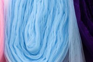 Detailed close up view on samples of cloth and fabrics in different colors found at a fabrics market photo