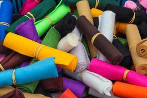 Detailed close up view on samples of cloth and fabrics in different colors found at a fabrics market photo