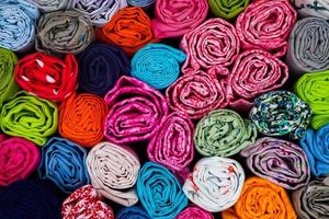 Detailed close up view on samples of cloth and fabrics in different colors found at a fabrics market photo