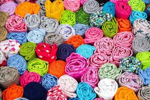 Detailed close up view on samples of cloth and fabrics in different colors found at a fabrics market photo