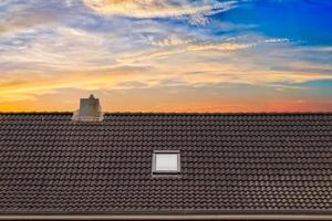 Roof window in velux style with dark roof tiles. photo