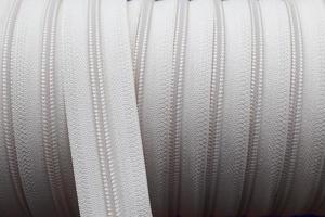 Detailed close up view on samples of zippers in different colors found at a fabrics market photo