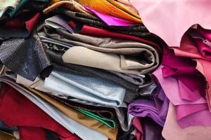 Detailed close up view on samples of cloth and fabrics in different colors found at a fabrics market photo