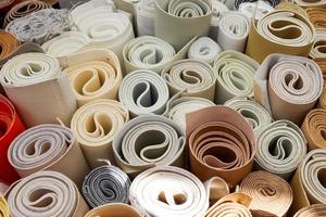 Close up view on rolled samples of cloth and fabrics in different colors found at a fabrics market.. photo