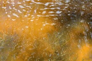 Detailed close up view on water surfaces with ripples and waves and the sunlight reflecting at the surface photo