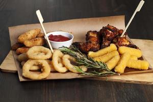 a set of dishes consisting of baked chicken wings , sets in a cafe photo