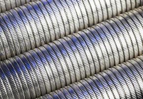 muchas monedas redondas de metal de color plateado iluminadas en azul foto