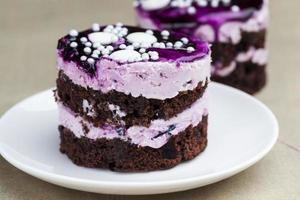 chocolate cake with cream covered with purple berry jam photo