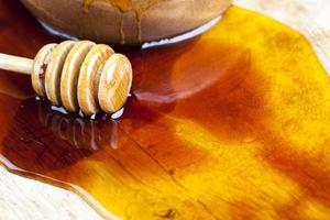 fresh bee honey poured on a board photo