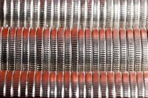 muchas monedas redondas de metal de color plateado iluminadas en rojo foto