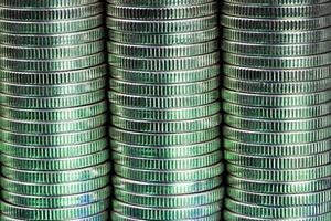 many round metal coins of silver color illuminated in green photo