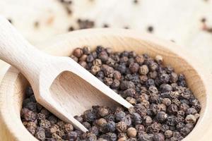 spice black pepper scattered on an old wooden table photo