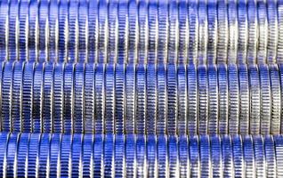 many round metal coins of silver color illuminated in blue photo