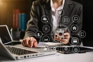 businesswoman or Designer using mobile phone with laptop and digital tablet laptop and document on desk in office with virtual icons network diagram photo