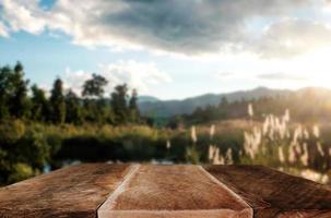 la parte superior vacía de los estantes de madera en el fondo de la vista frontal de la montaña del cielo y los árboles del río. para mostrar la imagen de fondo desenfocada del producto, para el producto foto