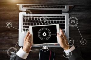 E-learning with connected gear cogs connected diagram virtual dashboard.top view of Designer hand working with laptop and smarth phone, tablet photo