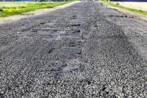 asphalt road that needs repaired photo