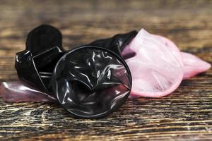 two quality latex condoms in pink and black photo