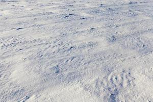 snow covered soil surface close up   snow covered soil surface is not smooth. Photographed close up. photo