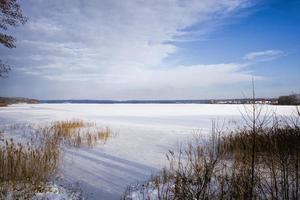 paisaje invernal con lago cubierto de nieve foto