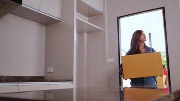 Slow motion shot, Asian young couple holding cardboard box walk into new house with happiness, new house concept video