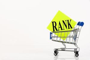 Shopping cart and text rank on yellow paper note list. Shopping list, business concept on white background. Copy space photo