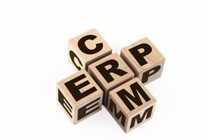 palabras crm y erp recopiladas en crucigramas con cubos de madera. planificación de recursos empresariales de erp, servicio de análisis de gestión de crm para clientes comerciales de crm. foto