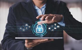 Cybersecurity and privacy concepts to protect data. Lock icon and internet network security technology. Businessman protecting personal data on smart phone with virtual screen interfaces. photo