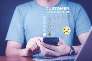 Customer Experience dissatisfied Concept, Unhappy Businessman Client with Sadness Face on smartphone screen, Bad review, bad service dislike bad quality, low rating, social media not good. photo