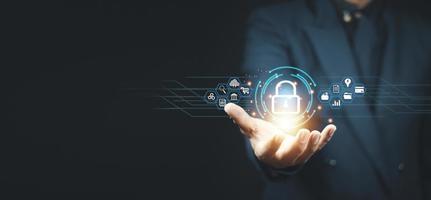 Cybersecurity and privacy concepts to protect data. Lock icon and internet network security technology. Businessman protecting personal data on smart phone with virtual screen interfaces. photo