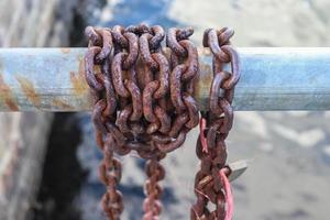 Rusty chain around metal bars at the port of Kiel. photo