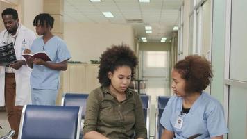 ambiente interno nos horários de funcionamento do posto de saúde, da sala de espera ambulatorial do hospital, grupos de médicos e estudantes de medicina conversam e caminham, discutem e consultam exames de pacientes. video