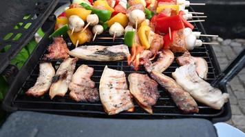 spiesjes van varkensvlees, vis en kip sissend op de barbecue, stock footage door brian holm nielsen video