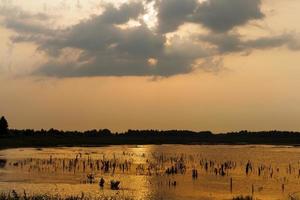 lake during sunset with yellow orange sky photo