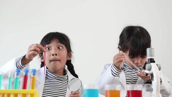 Slow motion shot, Asian siblings wearing coat using the device for experimenting with liquids. while studying science chemistry with exciting video