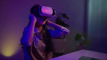 young  girl which applying virtual reality headset during working at home in the evening,modern technology concept video