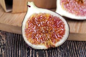 ripe purple figs on a wooden table photo