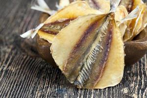 pescado pequeño seco y sacrificado en una mesa de madera foto