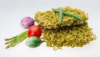 Green raw noodles on white background photo