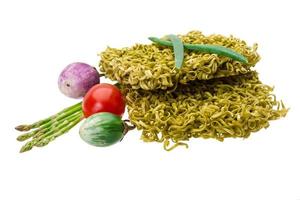 Green raw noodles on white background photo